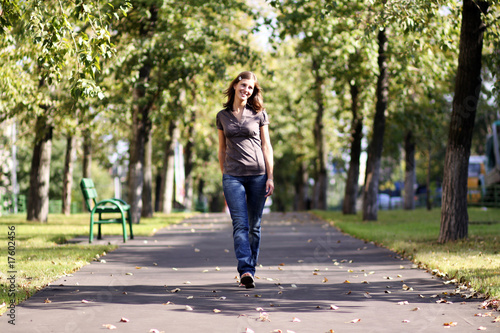 Full length, walking woman in blue jeans