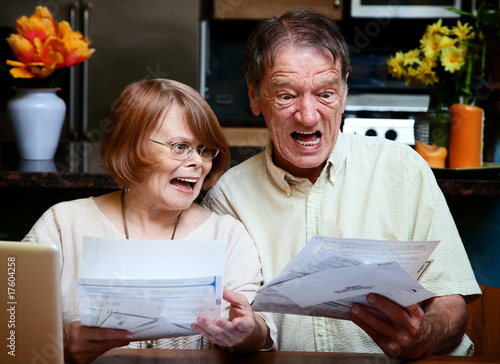 Senior couple at home with many bills photo