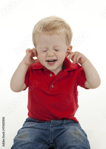 Young Boy Plugging His Ears and Closing His Eyes