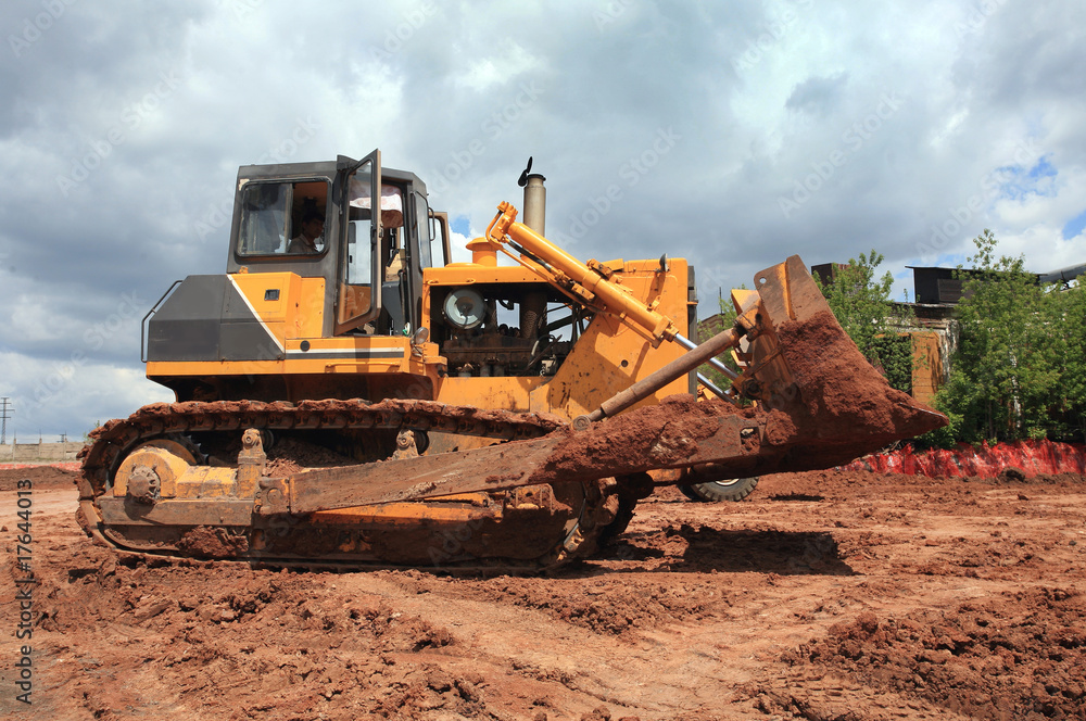 The heavy building bulldozer of yellow color The heavy building bulldozer of yellow color