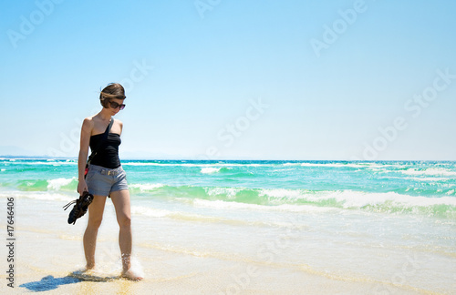 Attractive Brunette Walking Along a Sun Drenched Beach © JPRFphotos