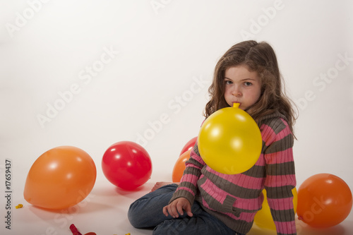 little girl playing with colorful balloons