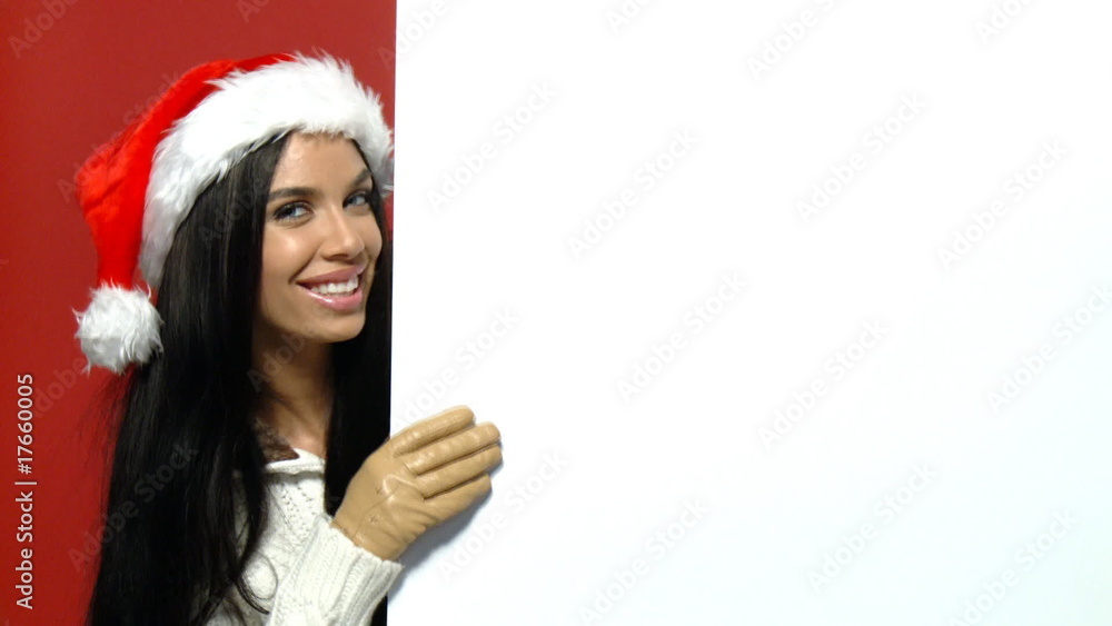 Girl in santa claus hat holding empty board Girl in santa claus hat holding empty board