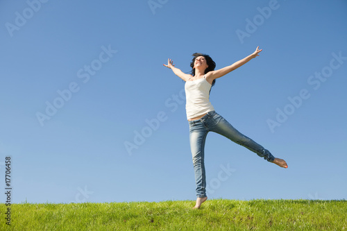 pretty young woman jumping on green grass