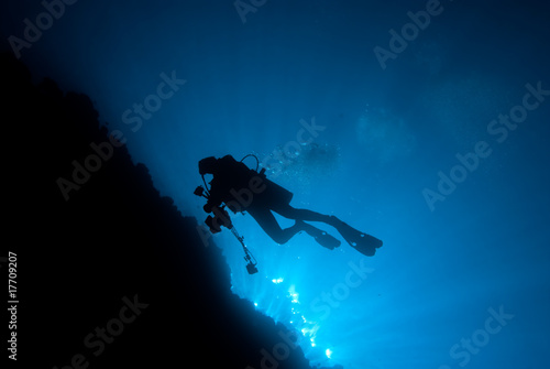 Silhouette of an underwater photographer