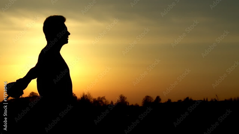 Man at sunset moving with sword Man at sunset moving with sword