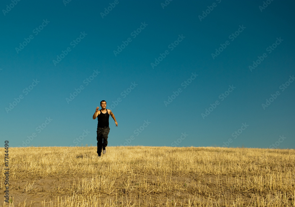 Handsome asian man running in the barley meadow in the hay time Handsome asian man running in the barley meadow in the hay time