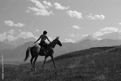 Girl riding a horse in the mountains