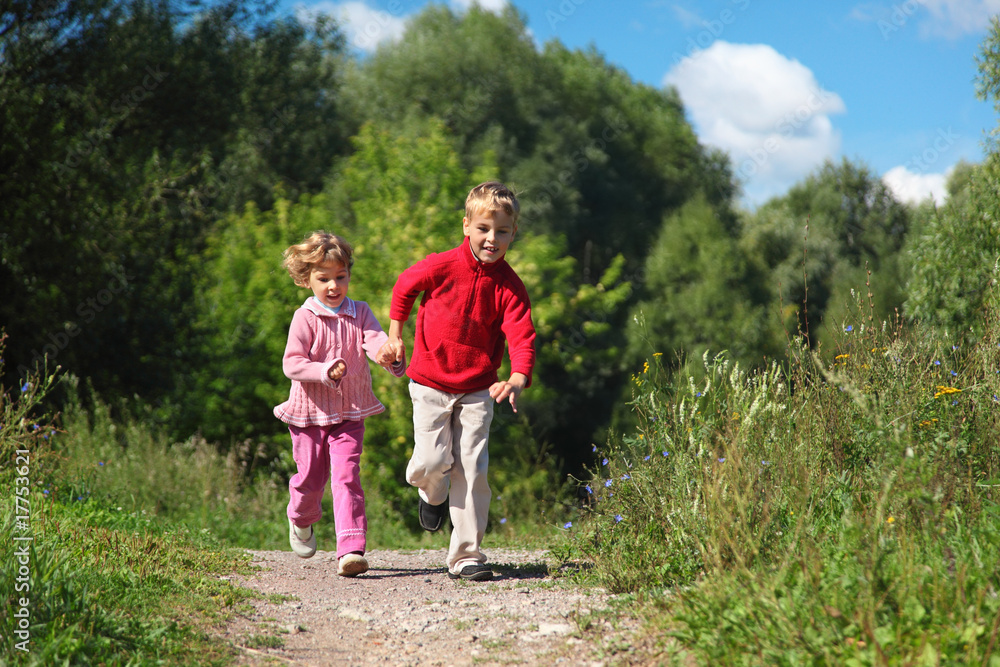 two children run on path in summer two children run on path in summer
