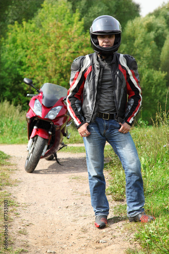 motorcyclist standing on country road near bike © Pavel Losevsky