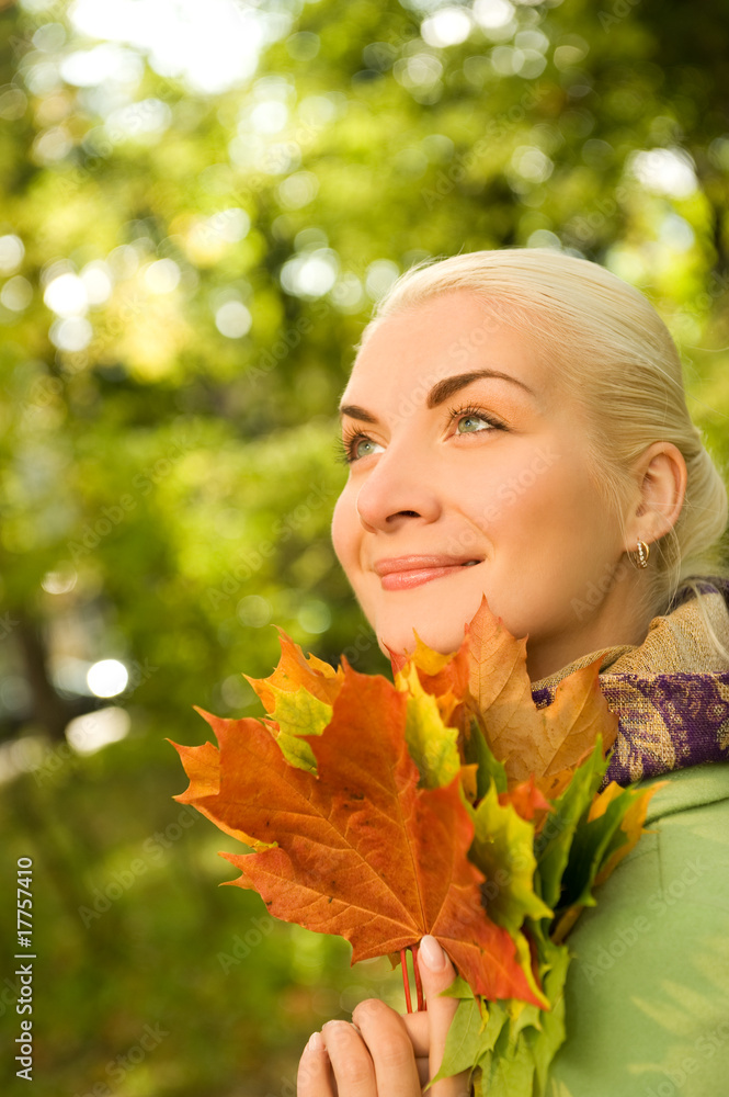 Woman with golden autumn leaves ....