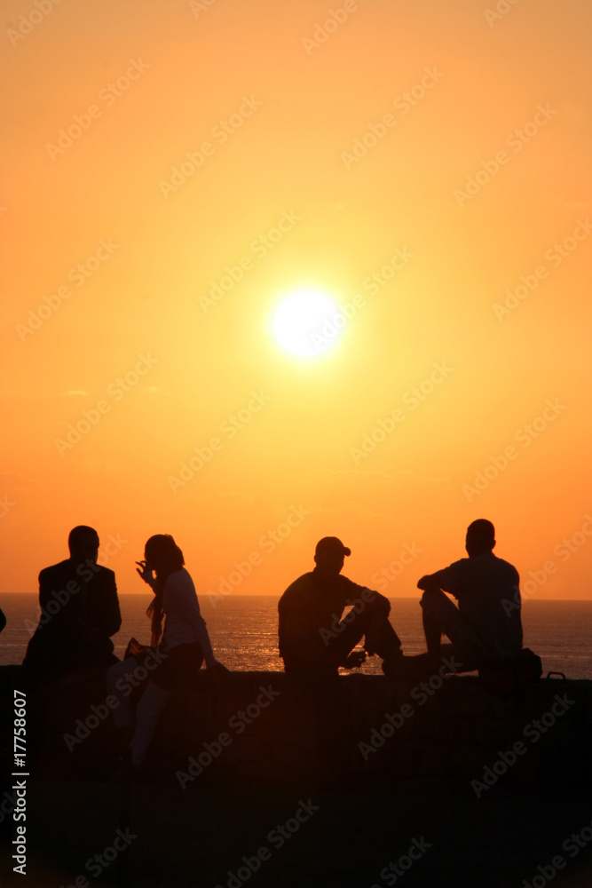 persone al tramonto in controluce