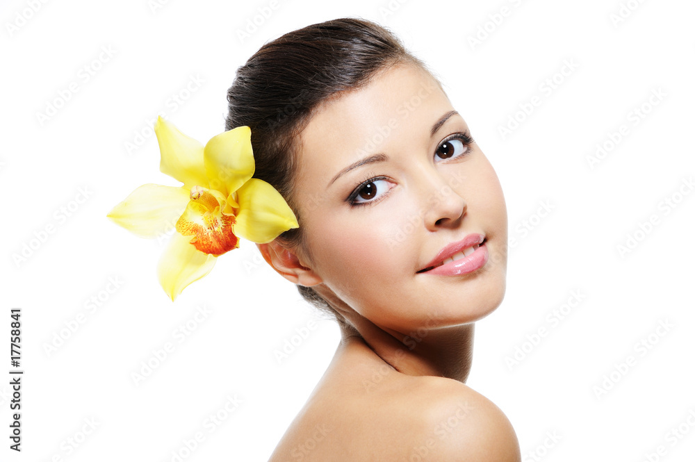 smiling female face with yellow orchid from her ear smiling female face with yellow orchid from her ear