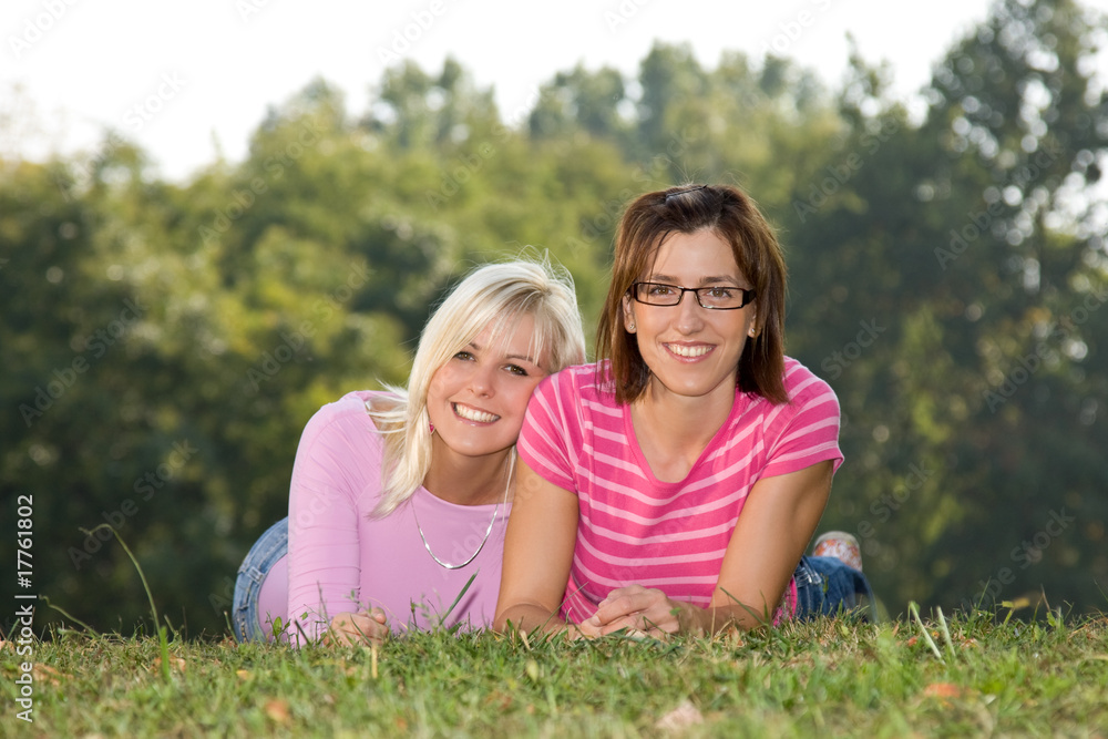 two girls lying in the park two girls lying in the park