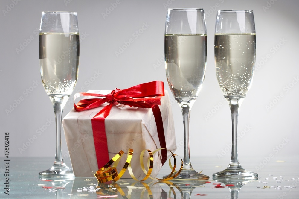 Glasses of champagne, gifts with red tapes and bows Glasses of champagne, gifts with red tapes and bows