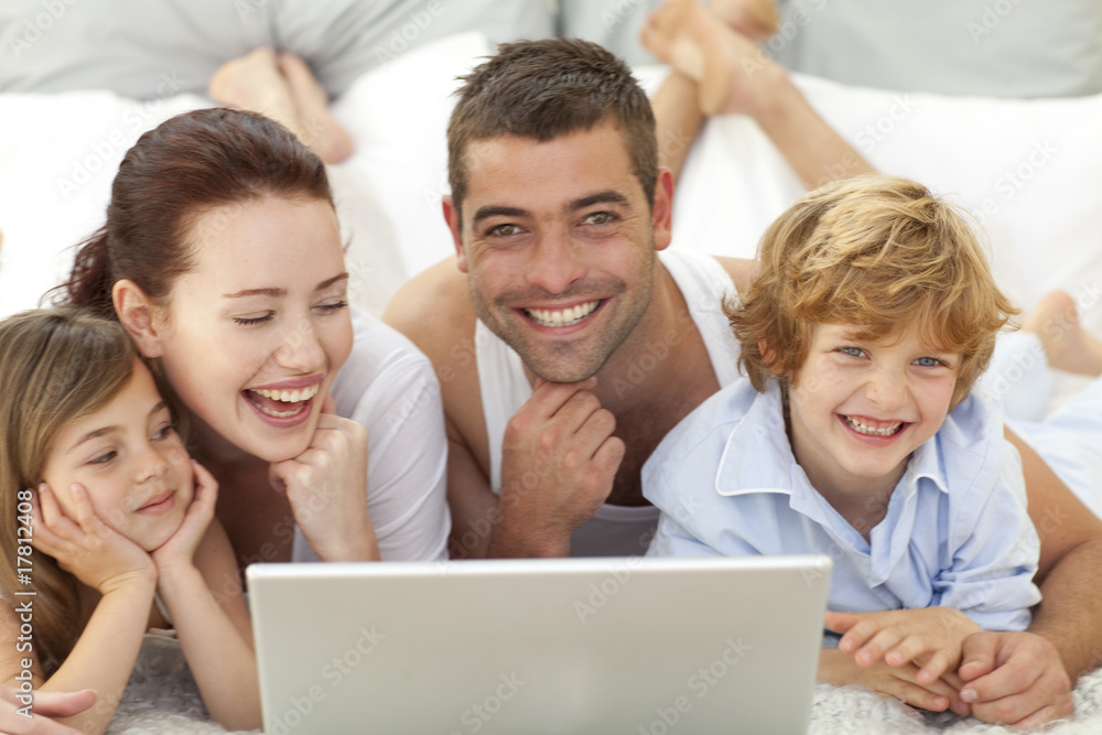 Family in bed having fun with a laptop Family in bed having fun with a laptop