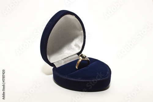 Gold ring with green saphire and brilliant in blue box on white
