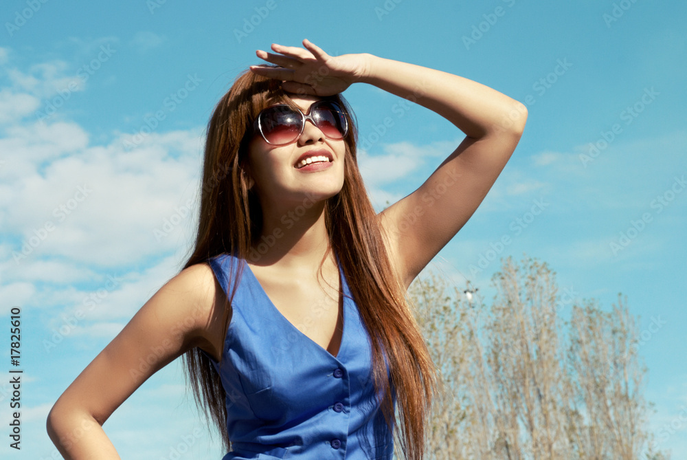 The young woman in sunglasses looking in a sky The young woman in sunglasses looking in a sky