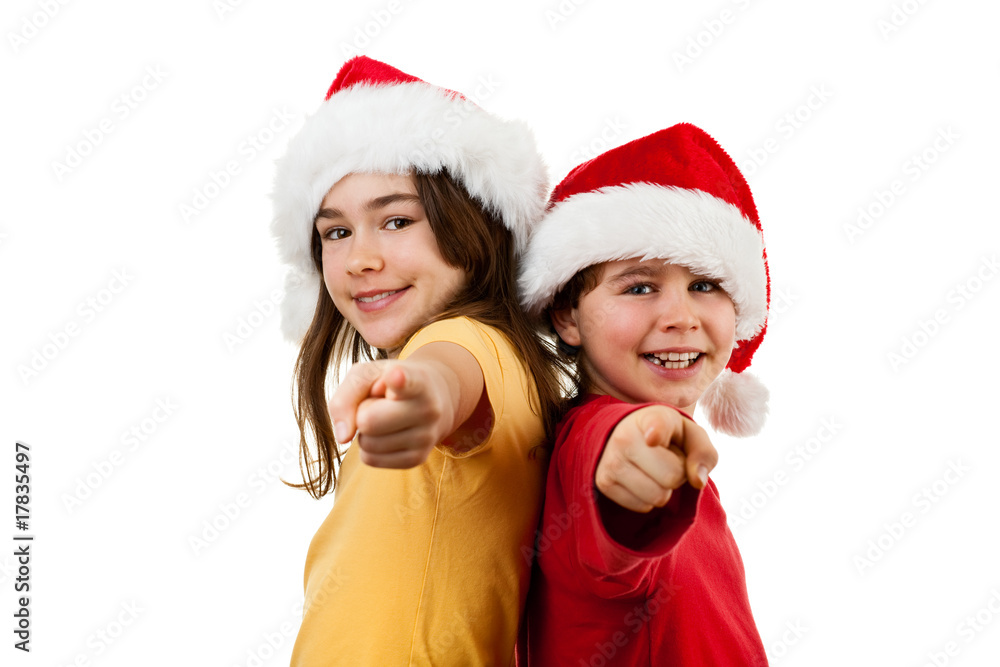 Kids wearing Santa Claus hats pointing isolated on white Kids wearing Santa Claus hats pointing isolated on white