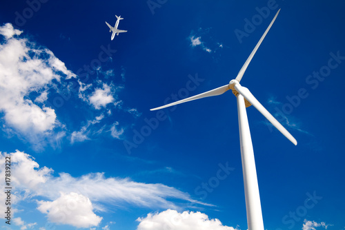 wind turbine on blue sky and airplane