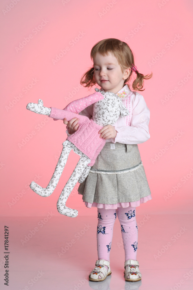 Little girl is playing with rabbit toy in studio Little girl is playing with rabbit toy in studio