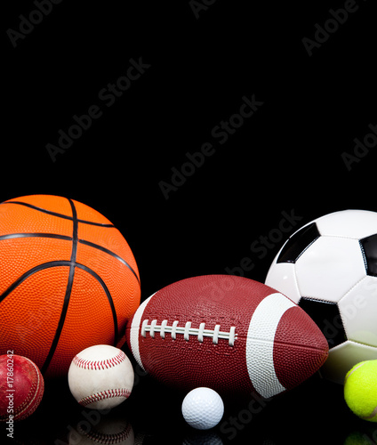 Assorted sports balls on a black background