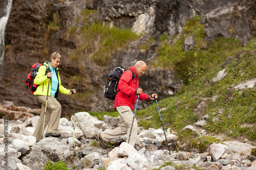 fit senior couple with rucksacks and hiking sticks