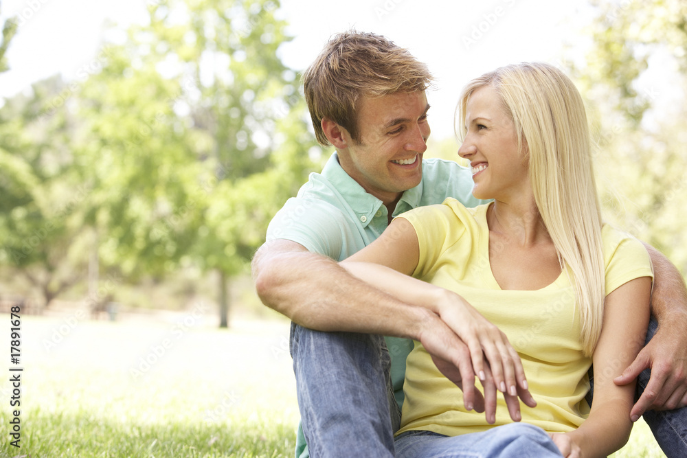 Portrait Of Young Couple Sitting In Park Portrait Of Young Couple Sitting In Park