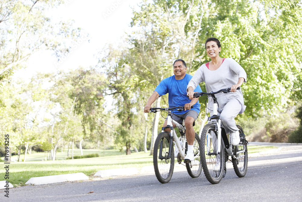 Senior Couple Cycling In Park