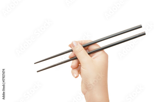 Chopsticks in a hand isolated on white