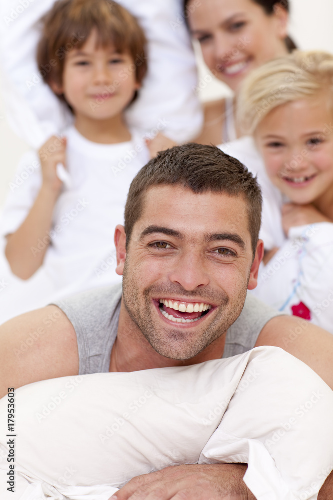 Obraz premium Family having a pillow fight in bed