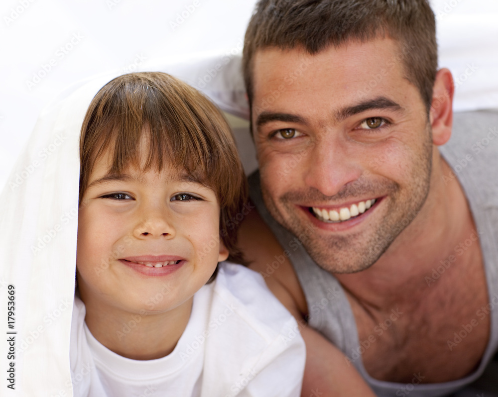 Father and son playing under the bedsheets Father and son playing under the bedsheets