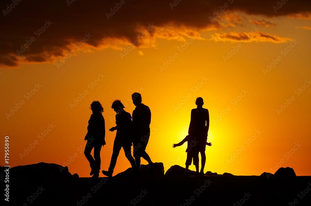 Silhouette of people on the beach at sunset