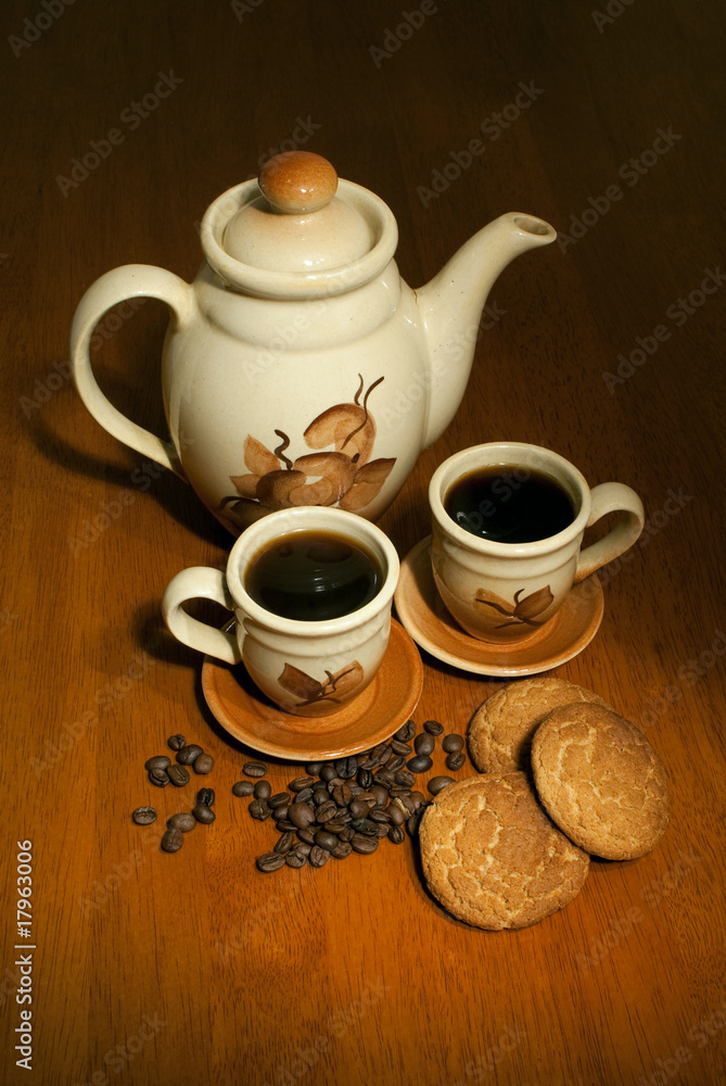 coffe pot with two cups on the wooden table in low key