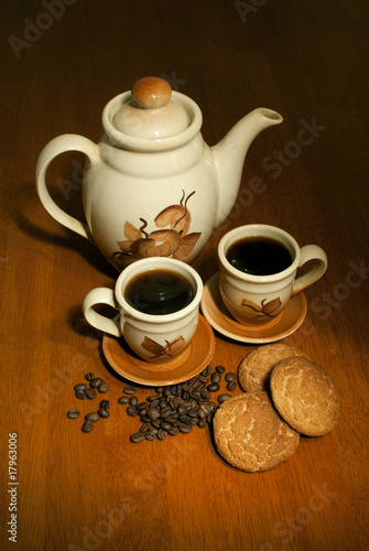 coffe pot with two cups on the wooden table in low key