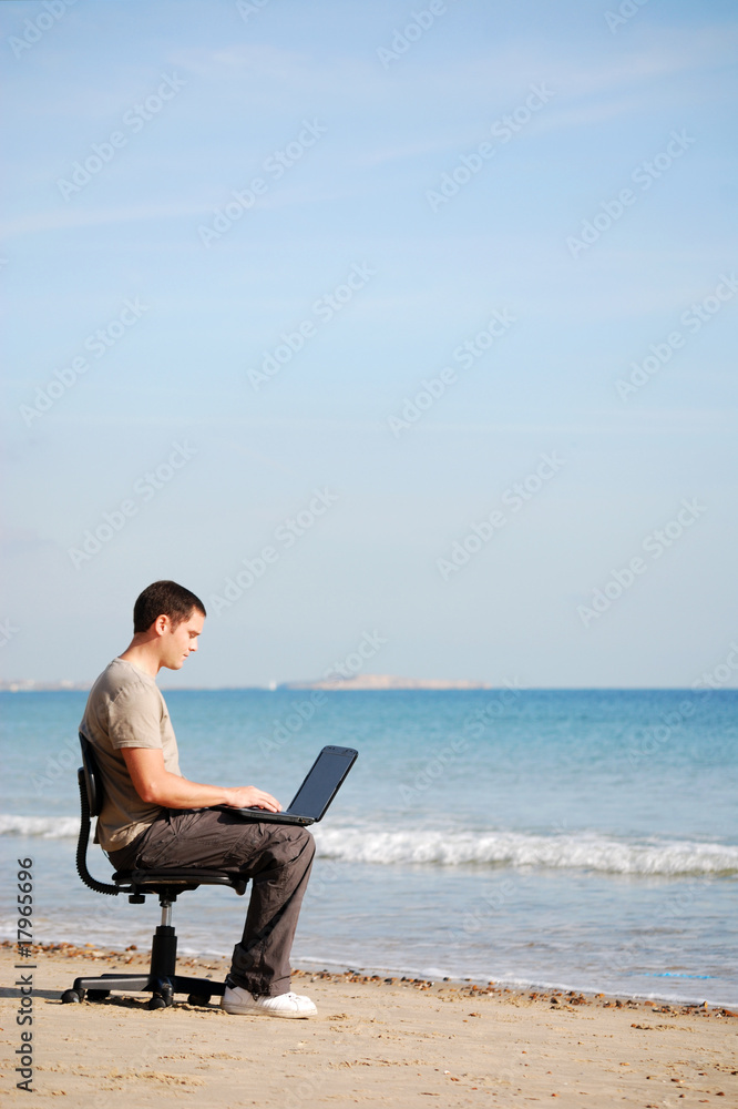 Man using his laptop at the beach