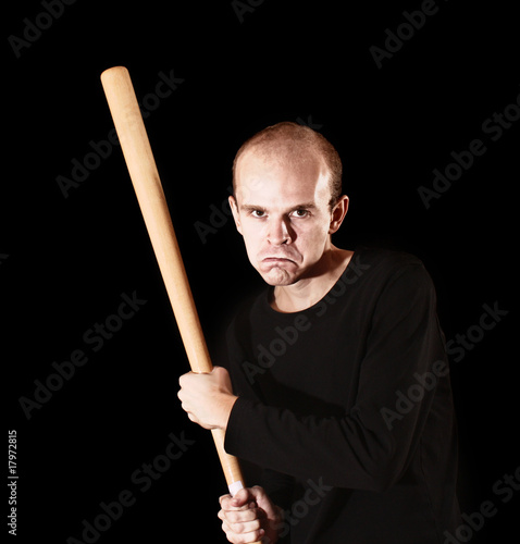 Man with baseball bat on black background