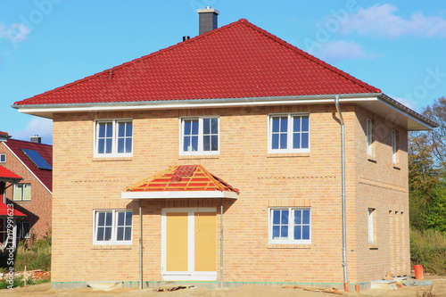 Neubau Einfamilienhaus Dachziegel Rohbau blauer Himmel