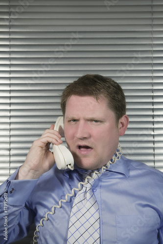 Caucasian Businessman busy and stressed Shouting down the teleph photo