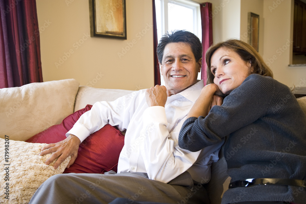 Mature affectionate couple sitting together on living room sofa Mature affectionate couple sitting together on living room sofa