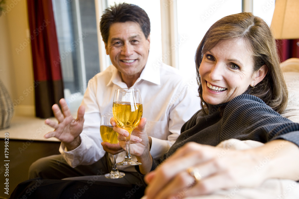 Mature couple drinking wine together on couch Mature couple drinking wine together on couch