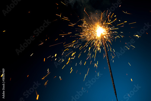 burning sparkler on blue photo