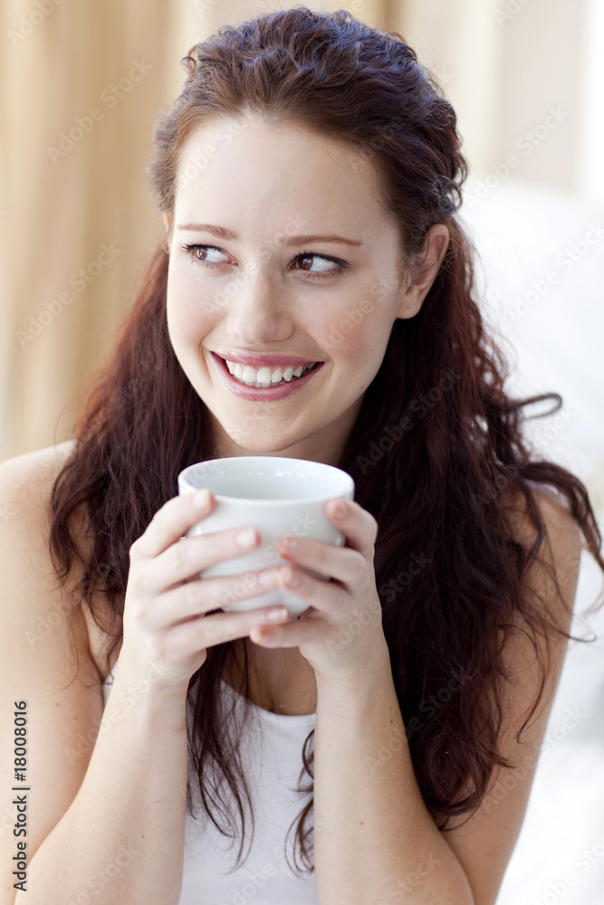 Beautiful woman drinking a cup of coffee in bed Beautiful woman drinking a cup of coffee in bed