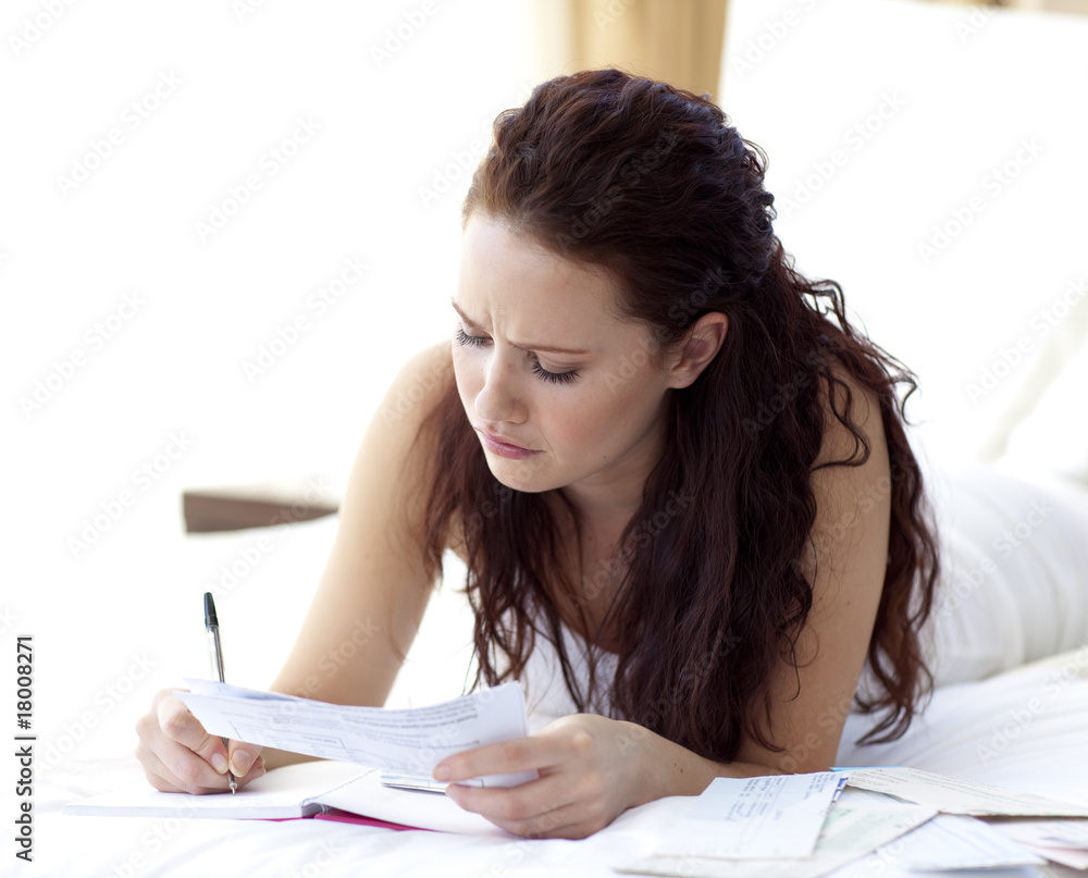 Fotografie Concentrated woman writing notes in bed