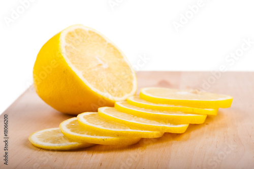 The lemon cut by segments lies on chopping board.