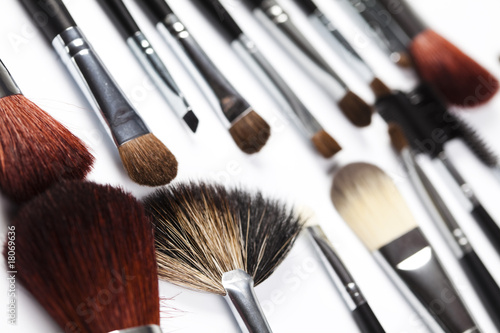 Cosmetic powder and black brushes isolated