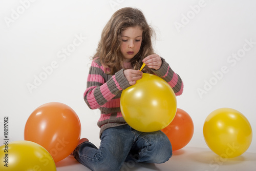 little girl playing with colorful balloons