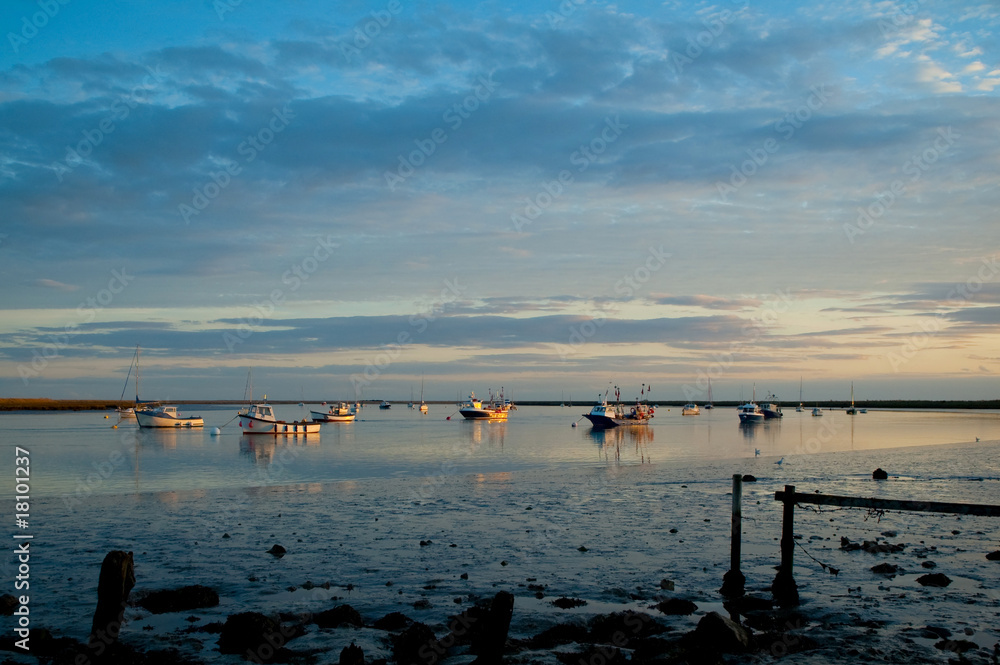 Obraz premium sunset over moored estuary fishing boats