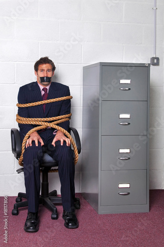 Businessman tied up in the office photo