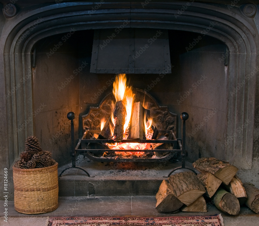 Stone fireplace with a lit roaring fire Stock Photo | Adobe Stock